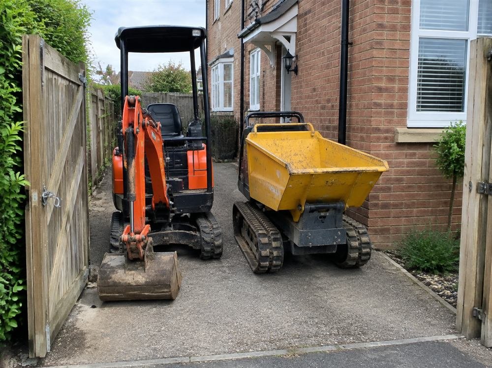 Mini digger and tracked dumper ready to go through a garden gate